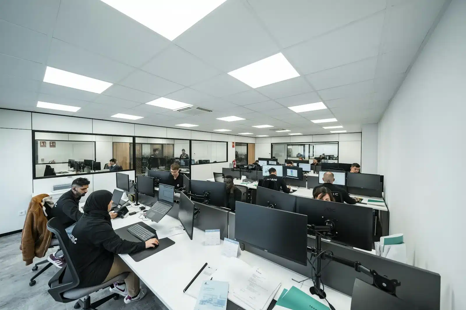 Open space où plusieurs personnes travaillent sur ordinateur